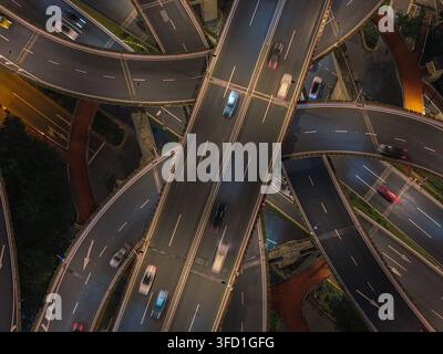 Luftbild des Yan'an Elevated Road Eingangs mit beleuchtetem Verkehr, der nachts durch die komplexe Autobahnkreuzung in Shanghai fließt, Shang Stockfoto