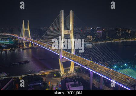 Luftbild der Nanpu-Brücke bei Nacht, beleuchtet, mit Verkehr, der über die kabelgespannte Struktur über den Huangpu-Fluss in Shanghai fließt, Shanghai, Stockfoto