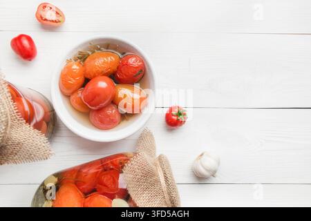 Eingemachtes Gemüse Tomate in Gläsern auf weißem Holzbrett. Blick von oben. Verschiedene Arten von Konserven. Hausgemachte Ernte fallen die Vorbereitungen. Stockfoto