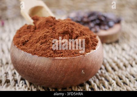 Gemahlener Kaffee in einer Holzschale auf einer gewebten Matte Stockfoto