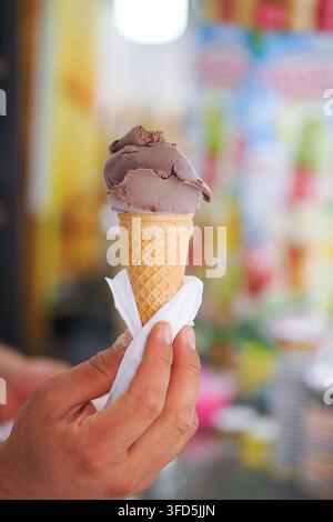 Person, die eine Schokoladeneiswaffel in der Hand hält Stockfoto