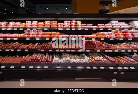 Taschkent, Usbekistan - 4. Oktober 2024: Eine Auswahl an russischen Würsten und Delikatessenfleisch, die im Kühlregal des Galmart-Supermarkts ausgestellt sind. Stockfoto