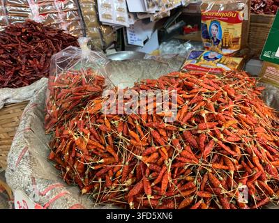 Bangkok, Thailand - 27. Dezember 2019: Getrocknete rote Chilischoten in einem gewebten Sack auf einem farbenfrohen lokalen Gewürzmarkt. Stockfoto