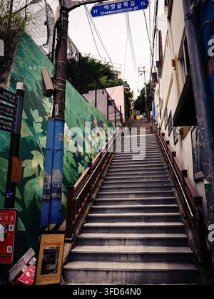 Steile Betontreppe, die durch eine enge Wohnstraße in Bosu-dong, Busan, Südkorea hinaufsteigt. Stockfoto