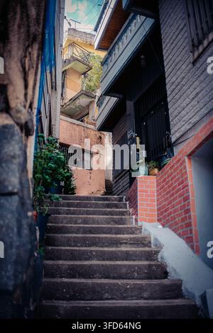 Steile Treppenanlage, die durch eine enge Wohnstraße in Daecheong-dong, Busan, Südkorea verläuft. Stockfoto