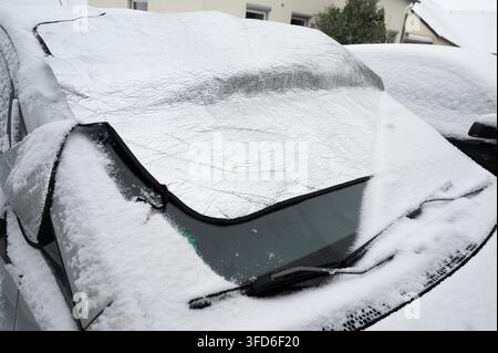 Auto mit Schnee bedeckt, isolierende Windschutzscheibenabdeckung, Schutzmatte, hält Fahrzeug frei von Eis, Schnee und Frost, Wintersaison, Transport Stockfoto