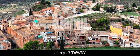 Luftbild eines kleinen Dorfes mit Terracotta-Dächern in der Nähe von Margalef, Katalonien, Spanien, eingebettet zwischen grünen Hügeln und Olivenbäumen. Eine charmante ländliche Siedlung Stockfoto