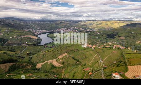 Lamego Portugal, Luftaufnahme von Lamego, Portugal. Sanfte Hügel bedeckt mit grünen Weinbergen und Ackerland. Ein Fluss windet sich durch das Tal und spiegelt die Wolken wider Stockfoto