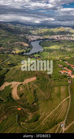 Lamego Portugal, Luftbild von Lamego, Portugal, zeigt einen gewundenen Fluss, der sich durch üppige grüne Hügel schneidet. Terrassenweinberge erklimmen steile Hänge, andeutend Stockfoto