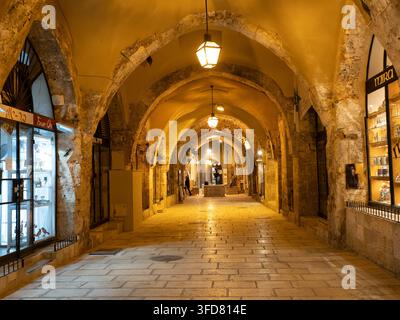 Jerusalem, Israel: Der rekonstruierte römische Steinuntergang mit beleuchteten Bögen und polierten Pflastersteinen bei Nacht in der Altstadt. Stockfoto