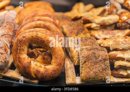 Verschiedene frische Brote und Baguettes in der Bäckereiauslage Stockfoto