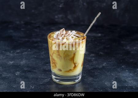 Grüner Avocado Smoothie mit schwarzem Kaffee und Kokosnusschips während des Frühstücks, Nahaufnahme Stockfoto