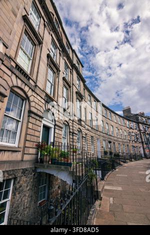 Traditionelle Edinburgher Steinhausfassade mit Treppen, die hinauf zur Haustür und hinunter zu einer Kellerwohnung führen, Schottland Stockfoto