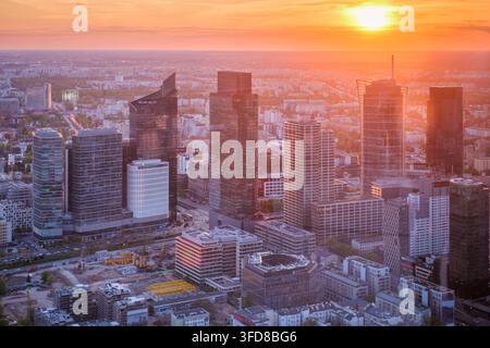 Weite Stadtsicht über die Warschauer Skyline in Polen mit Wolkenkratzern, Stadtbildschichten, breiten Alleen, Sonnenuntergangsfarben und dramatischem Himmel Stockfoto