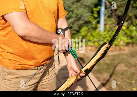 Bogenschützenhände, die Bogen und Pfeil halten, bereitmachen zum Zielen beim Schießen Stockfoto