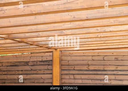 Nahaufnahme von verwitterten Holzträgern und horizontalen Brettern, die einen strukturierten architektonischen Hintergrund bilden Stockfoto
