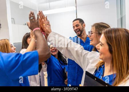 Medizinisches Team gibt High Five und feiert Erfolg und Teamarbeit Stockfoto