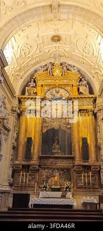Verzierter vergoldeter Altar mit Säulen und religiöser Skulptur unter einem verzierten Gewölbe im Inneren der Kathedrale von Baeza, Baeza, Spanien. Stockfoto