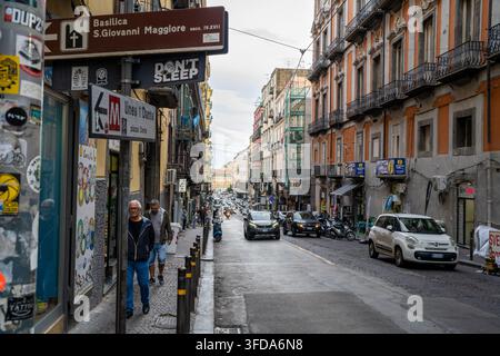 Neapel Italien - 29. September 2022: Menschen gehen auf dem Gehweg, während Autos eine belebte Straße in Neapel Italien entlangfahren Stockfoto