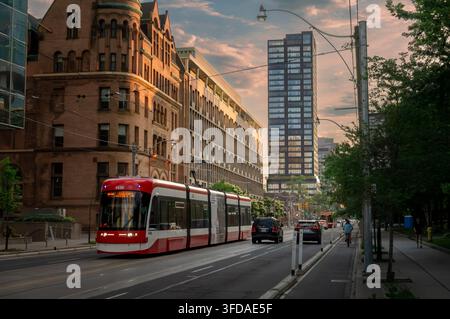 Toronto, Ontario, Kanada – 06 21 2025: Urbaner Verkehrsszene auf der College Street im Zentrum von Toronto mit einer modernen roten und weißen Straßenbahn Stockfoto