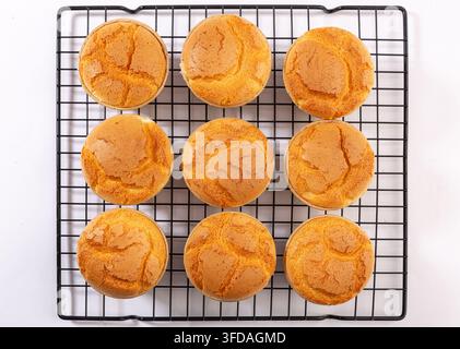 Frisch gebackene Reismehl-Schaum Muffins kühlen auf einem Drahtgestell Stockfoto