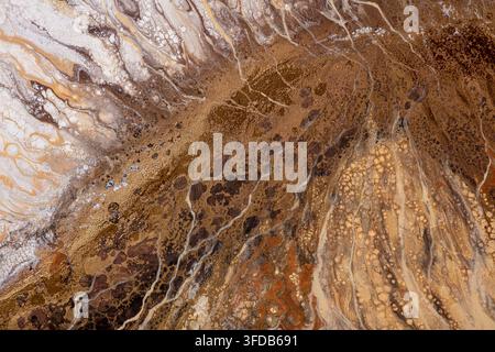 Abstrakte Acrylgußmalerei mit fließenden braunen, goldenen, rostfarbenen und cremefarbenen Adern und Blasenstrukturen, die eine marmorartige Steinstruktur über die gesamte Fläche bilden Stockfoto