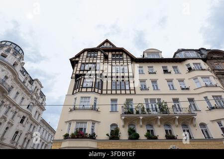 WIEN, ÖSTERREICH, 25. August 2026: Historische Wohnhäuser mit verzierten Fassaden werden aus einem niedrigen Winkel unter einem bewölkten Himmel gezeigt. Stockfoto