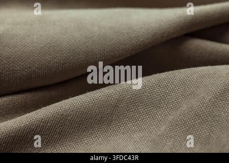 Braunes Leinenmaterial mit aufwendigem Gewebemuster und weichen Falten Stockfoto