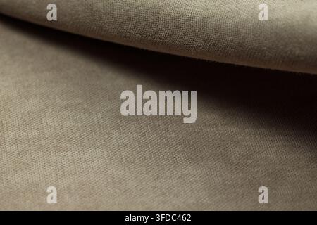 Beiger Stoff mit strukturierter Oberfläche und einer sanften Falte Stockfoto