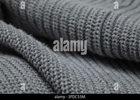 Grauer gestrickter Wollstoff, der eine warme, weiche und bequeme Textur für Hintergründe präsentiert Stockfoto
