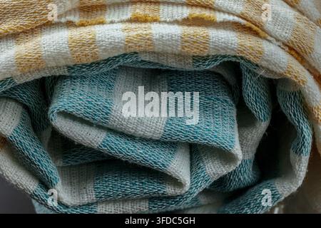 Gerolltes Baumwolltextil mit kariertem Muster in Türkis, Gelb und Weiß Stockfoto