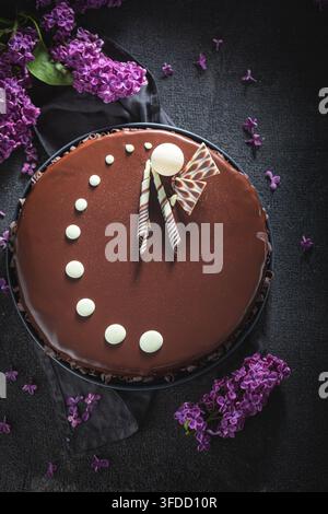 Frisch gebackener Schokoladenkuchen, dekoriert mit Sommerblumen. Warmer Schokoladenkuchen, dekoriert mit hellen Sommerblüten. Stockfoto