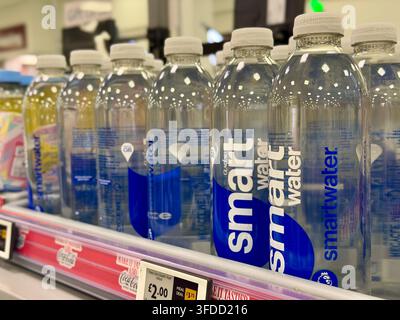 Flaschen von Smartwater zum Verkauf in einem britischen Supermarkt, ein konzeptionelles Bild, das den Wasserverbrauch, die Knappheit und die wachsende Nachfrage nach Wasser aufgrund von KI-Daten veranschaulicht Stockfoto