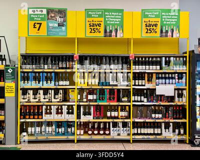 Morrisons-Weinregal wirbt mit More-Card-Preisen und 25 % Rabatt beim Kauf von sechs oder mehr ausgewählten Weinen und Champagner in einem britischen Supermarkt. Stockfoto