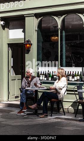 Ein gemischtrassiges Paar sitzt außerhalb eines Restaurants, Zentral-London, England, UK. Stockfoto