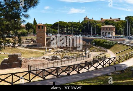 Rom, Italien - 15. Juni 2026: Antike Ruinen des Circus Maximus mit einem Steinturm und grasbewachsenen Bereichen, umgeben von Bäumen und modernen Gebäuden in Rom Stockfoto