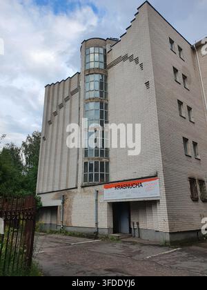 Ein mehrstöckiges Gebäude aus hellen Ziegeln mit einem markanten architektonischen Design und rechteckigen Fenstern in den oberen Stockwerken Stockfoto