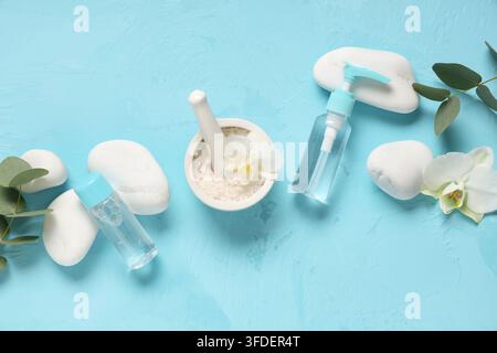 Komposition mit Kosmetikprodukten, Kursteinen und Eukalyptuszweigen auf farbigem Hintergrund Stockfoto