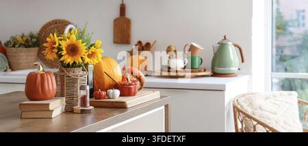 Herbstliche Wohnkultur und saisonaler Lebensstil, Sonnenblumen und Kürbisse auf der Küchentheke mit gemütlichen Innenelemente für die Erntefest-Feier im Herbst Stockfoto