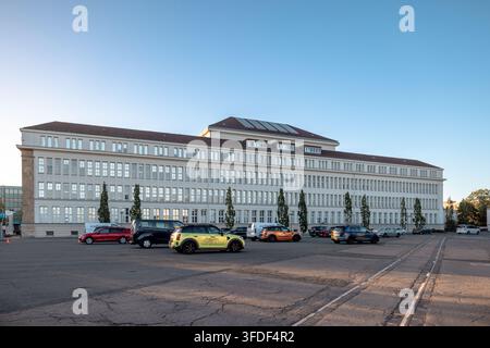 Großes historisches Industriegebäude mit langer symmetrischer Fassade und geparkten Fahrzeugen in einem ehemaligen Produktionskomplex in Hannover. Stockfoto
