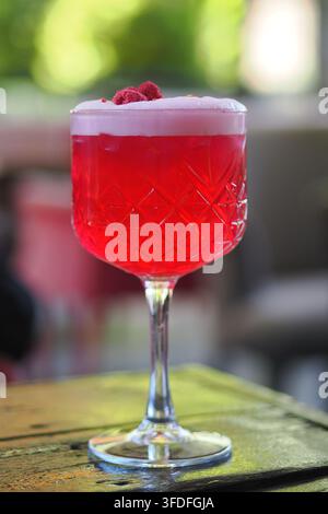 Getränk in einem Glas mit roter Farbe und Schaum oben Stockfoto