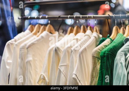 Weiße und grüne Strickwaren auf einem Boutique-Kleiderständer Stockfoto