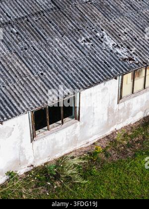 Luftbild eines verlassenen landwirtschaftlichen Gebäudes aus der Sowjetzeit mit einem verwitterten Wellblechdach und weißen Wänden, Kulciems, Bezirk Talsi, Lettland. Stockfoto