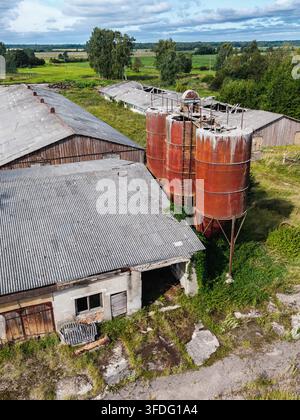 Luftbild eines verlassenen landwirtschaftlichen Komplexes aus der Sowjetzeit mit verrosteten Silos und verfallenen Gebäuden in der ländlichen Landschaft Kulciems, Talsi Municipali Stockfoto