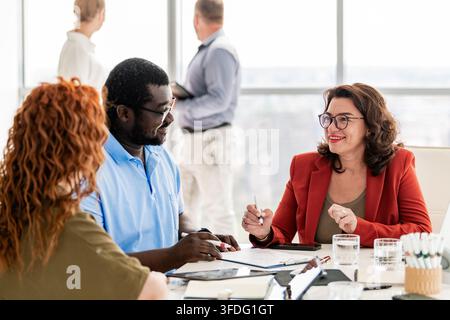 Verschiedene Geschäftskollegen lächeln während einer Teambesprechung Stockfoto