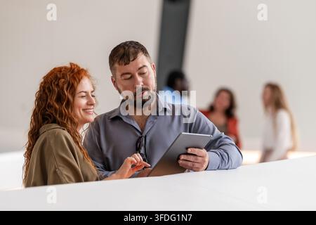 Lächelnde Kollegen betrachten ein digitales Tablet Stockfoto