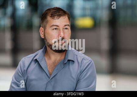 selbstbewusster, ernster, bärtiger Mann schaut geradeaus. Stockfoto