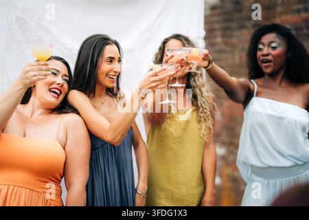 Verschiedene Freunde feiern mit Cocktails auf einer Party Stockfoto