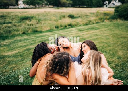 Verschiedene Freunde in einer zärtlichen Gruppenumarmung im Freien Stockfoto