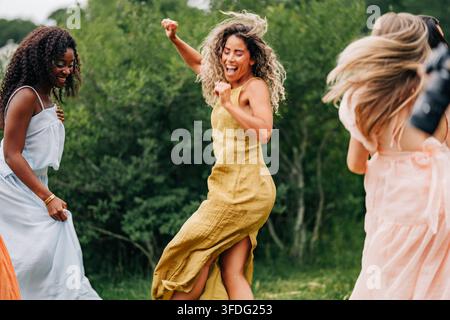 Fröhliche Frauen tanzen und lachen zusammen draußen Stockfoto